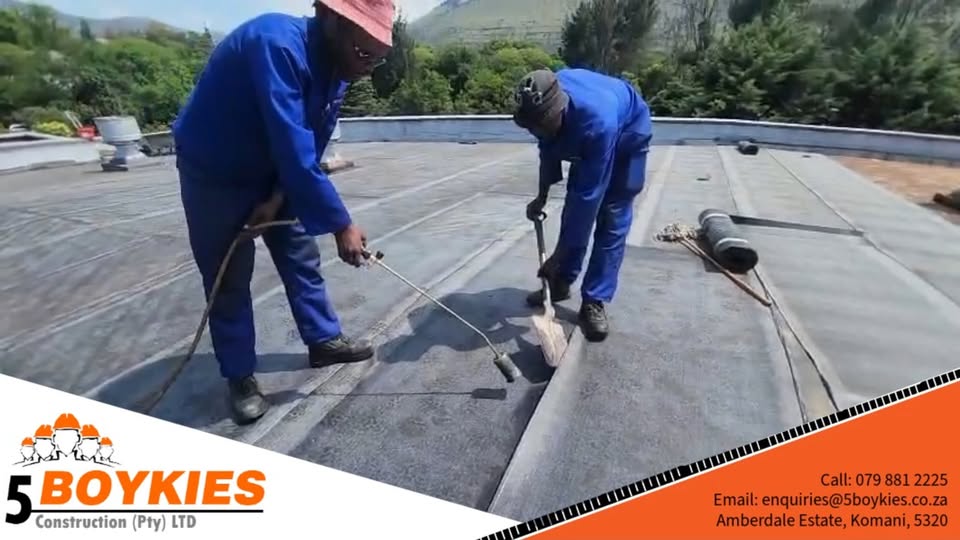 Two workers sealing joints on a flat roof with the ABE Index system